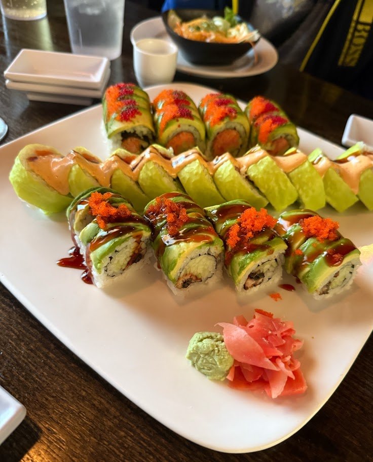 Sushi plates arranged beside a glowing water wall.